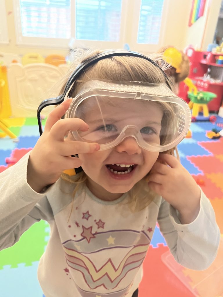 Little girls learns to wear safety goggles